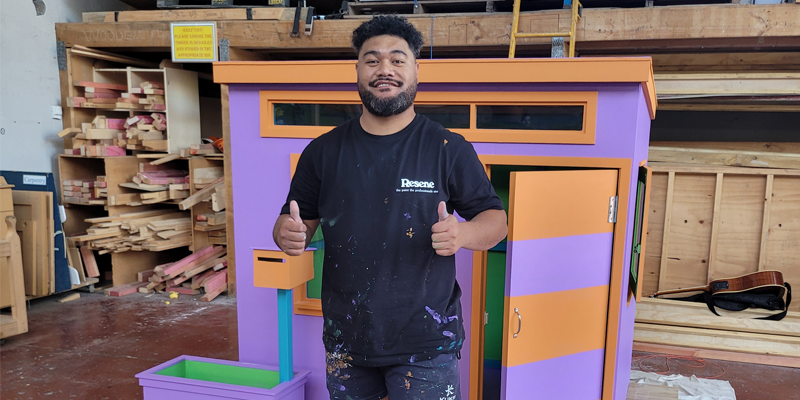 2021 Painting Apprentice of the Year - Tuaine Ruatita with the playhouse he built and painted at the apprentice of the year competition 2021